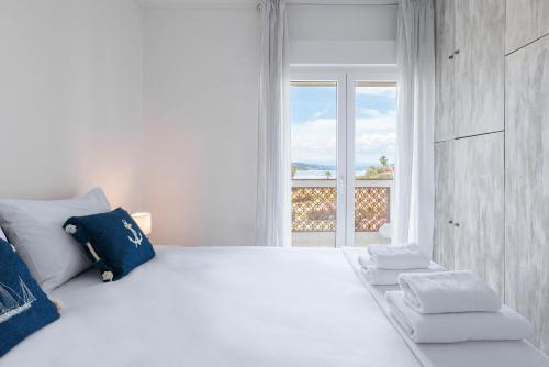 Un dormitorio blanco con una gran cama blanca y una ventana. en F & B Summer Collection - Sithonia - Family Maisonette, en Ormos Panagias