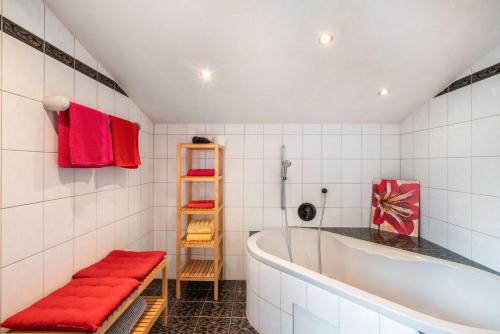 Un baño con bañera y toallas rojas. en Ferienwohnung Edelweiß, en Schönau am Königssee