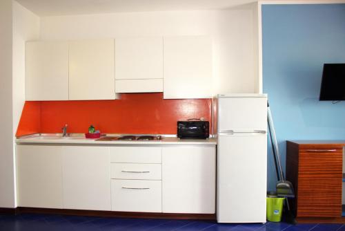 a kitchen with white cabinets and a white refrigerator at Residence Adriatico in Gabicce Mare