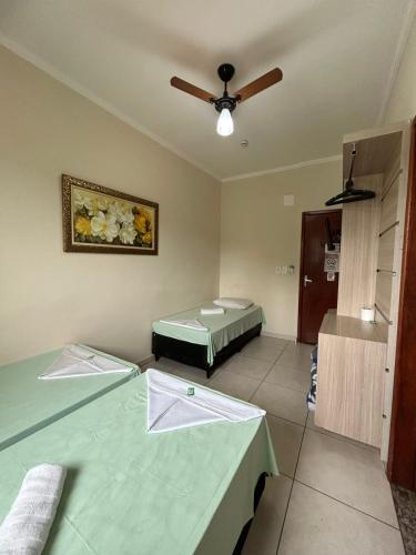 a room with two beds and a ceiling fan at Hotel São João Paulo II in Aparecida