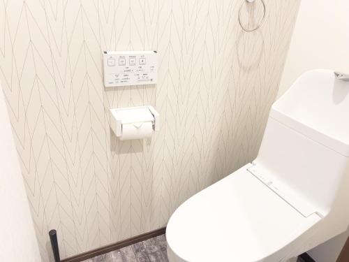 a bathroom with a white toilet and a sink at Prevoyance前原中央 in Itoshima