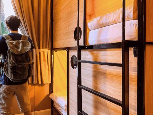 a man looking out of a door into a bedroom at Gardiner House Hostel in Dublin