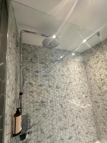 a bathroom with a shower with a white tiled wall at Best Western Plus Le Picardy in Saint-Quentin