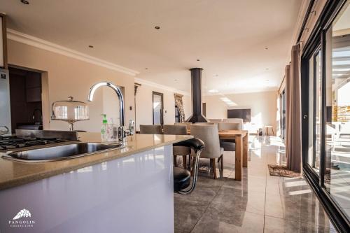 a kitchen with a sink and a dining room at Twelve Tumbleweed, Cathkin Estates by Euphoric Leisure in Champagne Valley