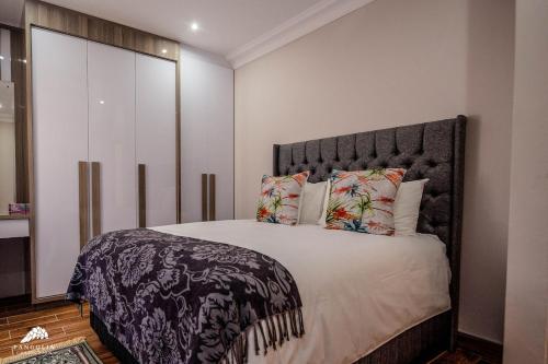 a bedroom with a large bed with a large headboard at Twelve Tumbleweed, Cathkin Estates by Euphoric Leisure in Champagne Valley