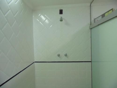 Łazienka z prysznicem i białymi ścianami wyłożonymi kafelkami. w obiekcie Amarhotel w São Paulo