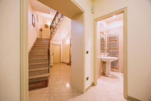 a hallway with a staircase and a sink at CasAdòro in Arezzo