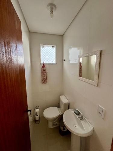 ein Badezimmer mit einer weißen Toilette und einem Waschbecken in der Unterkunft Casa prox. a praia do Campeche in Florianópolis