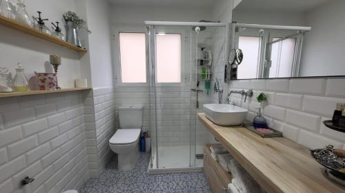Un baño blanco con lavabo e inodoro. en Mediterraneo, en Santa Pola