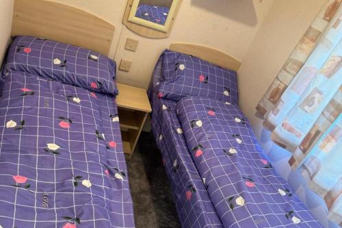 シェアーネスにあるSeaside Bliss Retreat in heart of isle of sheppyの小さな部屋のベッド2台 紫色のシーツ付