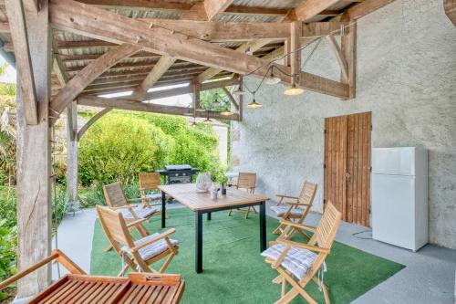 d'une terrasse avec une table, des chaises et un réfrigérateur. dans l'établissement Maison de Campagne à Cunèges, à Cunèges