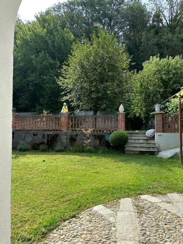 a brick fence in a yard with grass and trees at Lunafragola Atelier B&B in Candia Canavese