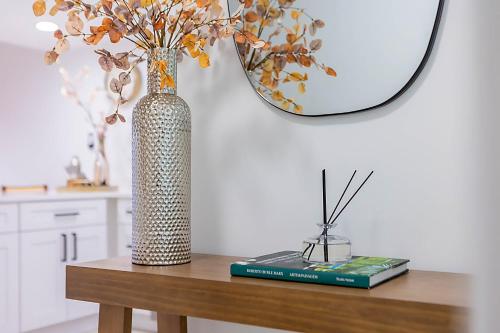 a vase and a book on a table with a mirror at Gorgeous Beach Front Condo Near Flagler Ave - 701 in New Smyrna Beach