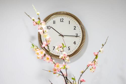 a clock on a wall with flowers on it at Gorgeous Beach Front Condo Near Flagler Ave - 701 in New Smyrna Beach