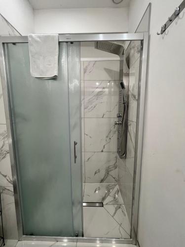 a shower with a glass door in a bathroom at Apartmani Gandi in Bihać