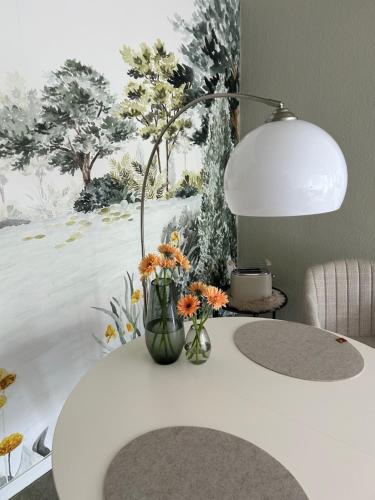 a white table with a vase of flowers on it at Herzlichstharz - Klein und Fein in Bad Lauterberg