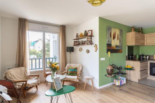 - un salon avec des murs verts, une table et des chaises dans l'établissement Les pins 102 - 5min à Pied de la Plage, à Fréhel