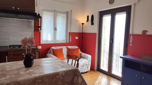 a kitchen with a table and a chair and red walls at Tana Libera Tutti 1 Nature, Yourself, Love in Viggianello