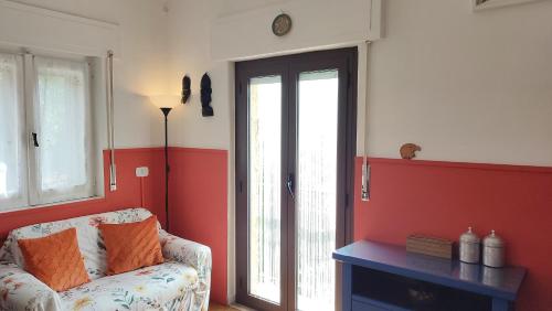 a living room with a couch and a red wall at Tana Libera Tutti 1 Nature, Yourself, Love in Viggianello
