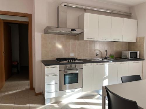 a kitchen with white cabinets and a stove top oven at Alò! in Arezzo