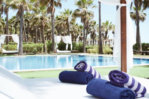 a pair of blue towels sitting on a bed next to a swimming pool at VidaMar Resort Hotel Algarve in Albufeira