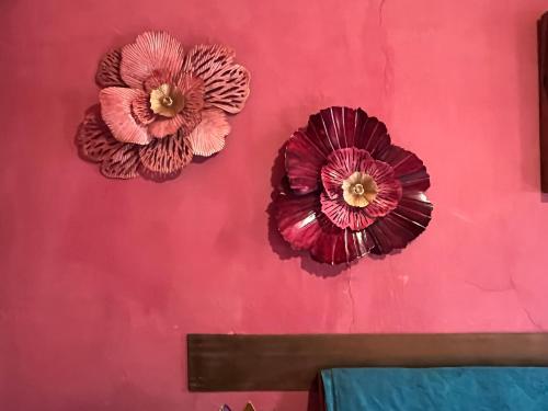 two paper flowers on a red wall at Lunafragola Atelier B&B in Candia Canavese
