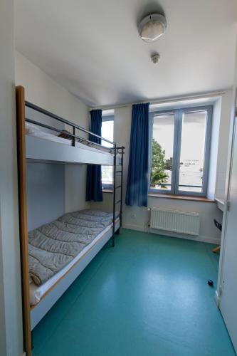 a bedroom with two bunk beds and a window at Auberge de Jeunesse HI Cherbourg in Cherbourg en Cotentin