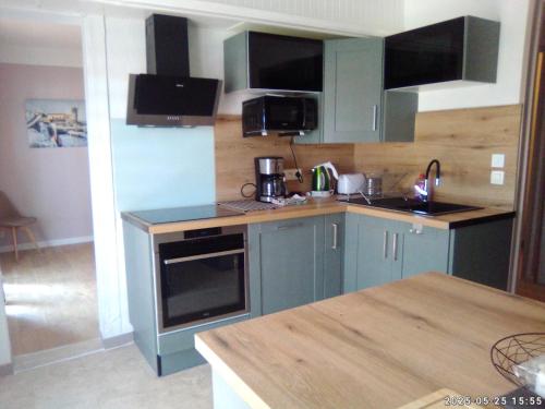 une cuisine avec des armoires bleues et un comptoir dans l'établissement Gîte les Albères, à Saint-André