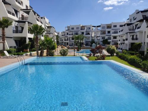 a swimming pool in front of a apartment complex at Résidence Tamuda Golf à Cabo Negro in Cabo Negro