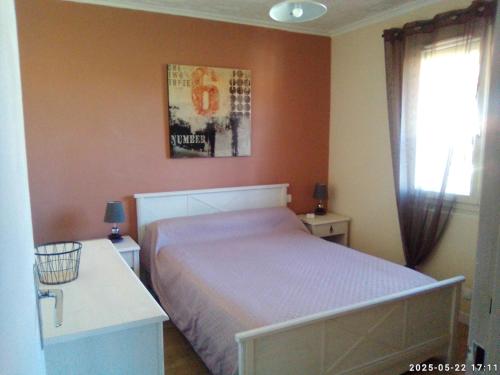 une chambre avec un grand lit et une fenêtre dans l'établissement Gîte les Albères, à Saint-André