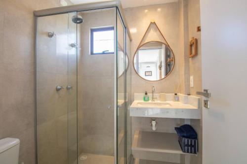 ein Badezimmer mit Dusche, Waschbecken und Spiegel in der Unterkunft OKA Milagres Cond. Beira Mar para 08 Pessoas in Barra do Camaragibe