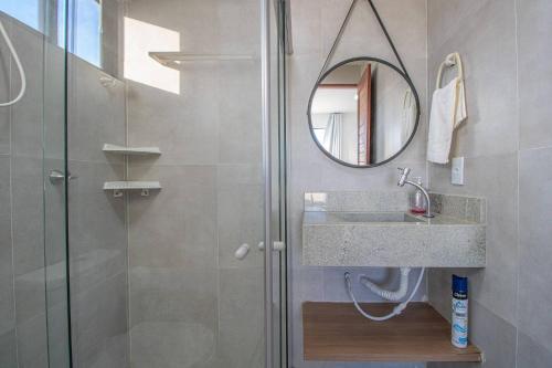 a bathroom with a shower with a sink and a mirror at Casa Milagres 03 suítes - a 300m da Praia in Tatuamunha