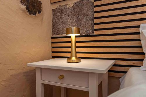 a white table with a gold lamp on top of it at Casa Justina in Garachico
