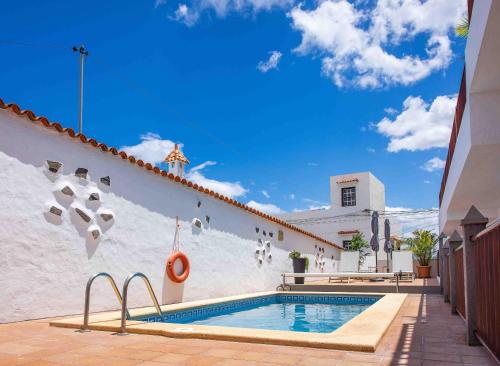 a pool in the side of a white building at Casa Justina in Garachico