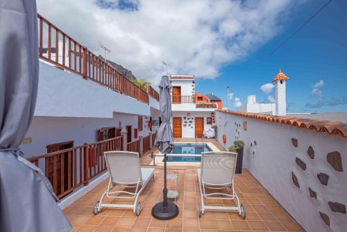 a balcony with chairs and a swimming pool on a house at Casa Justina in Garachico