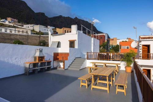 a patio with a table and benches on a building at Casa Justina in Garachico