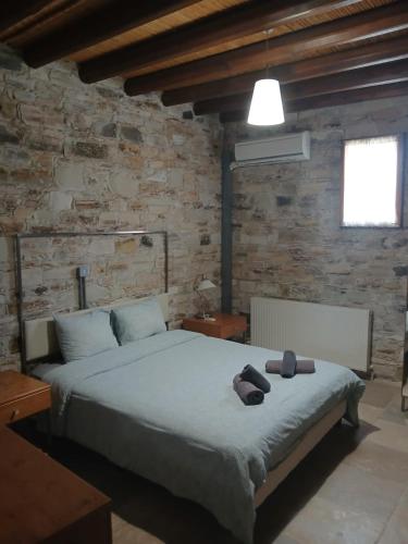 a bedroom with a large bed in a brick wall at Skarinou's Landhouse Poolside Heaven Apartment in Skarinou