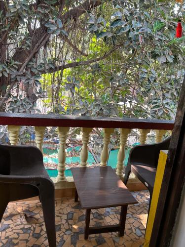 a table and two chairs in front of a window at Fatima Guest House in Baga
