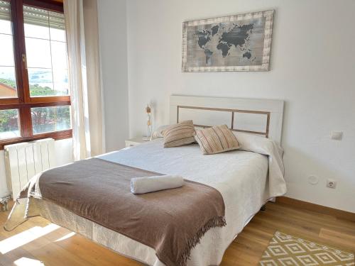 a bedroom with a large bed with a large window at El Rincón de la Playa in Mogro
