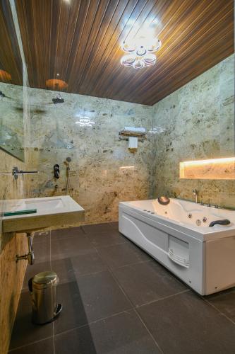 a bathroom with a bath tub and a sink at The Byke Stella Boutique Hotel Pan India Pure Veg Hotel Chain in Indore