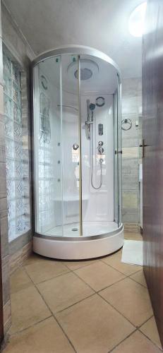 a bathroom with a shower with a glass door at Goggas Nest BNB & Restaurant in Matsapha