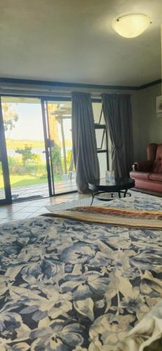 a living room with a couch and a table on a rug at Goggas Nest BNB & Restaurant in Matsapha