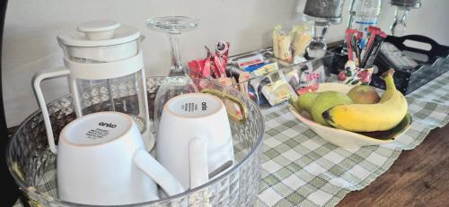 a kitchen counter with a basket of fruit and appliances at Goggas Nest BNB & Restaurant in Matsapha