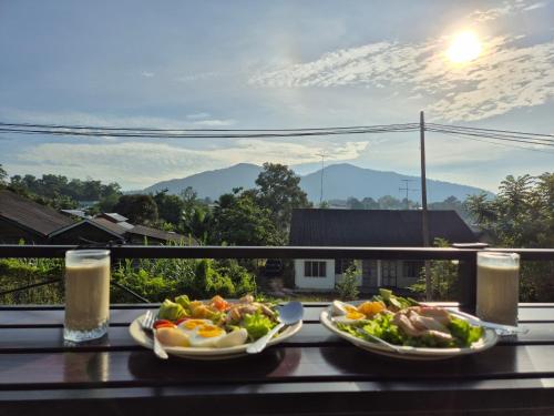 two plates of food on a table on a balcony at Villa Kluang 峦山居 in Kluang