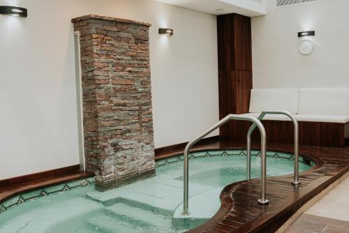 a hot tub in a room with a brick pillar at Blank Hotel Recoleta in Buenos Aires