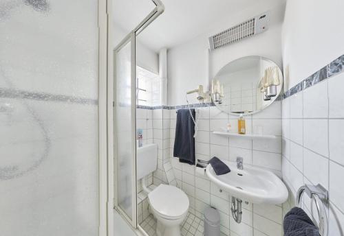 a bathroom with a toilet and a sink and a mirror at Pension Am Sültebrunnen in Bad Oeynhausen