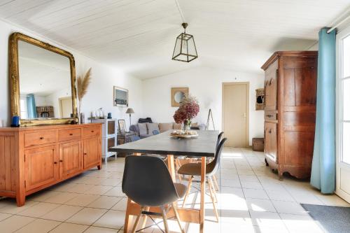 a dining room with a table and chairs and a mirror at Maison pour 6 à Noirmoutier - jardin - terrasse in Noirmoutier-en-l'lle