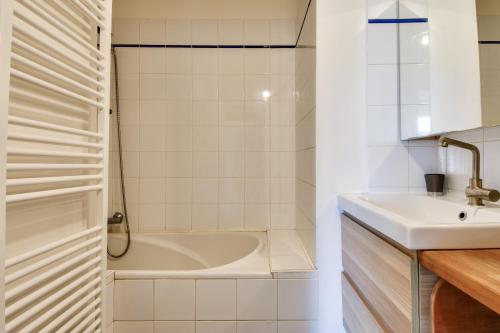a white bathroom with a tub and a sink at Maison pour 6 à Noirmoutier - jardin - terrasse in Noirmoutier-en-l'lle