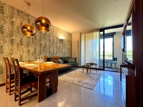 a dining room and living room with a table at La Libellula - [Parcheggio gratuito] in Alba