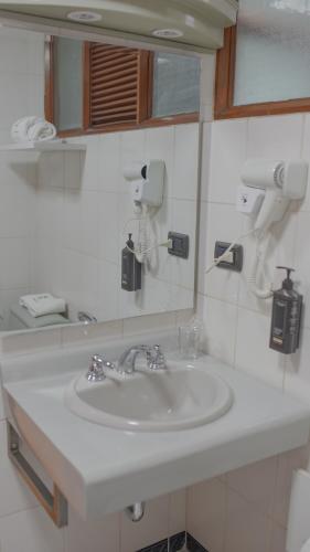a bathroom with a white sink and a mirror at Hotel Continental (Cajamarca) in Cajamarca